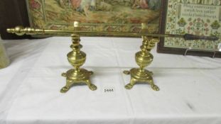 A pair of Victorian brass fire dogs and a brass poker.