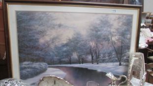 A large framed and glazed winter scene print.