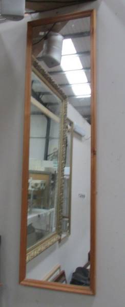 A tall slim pine framed mirror.