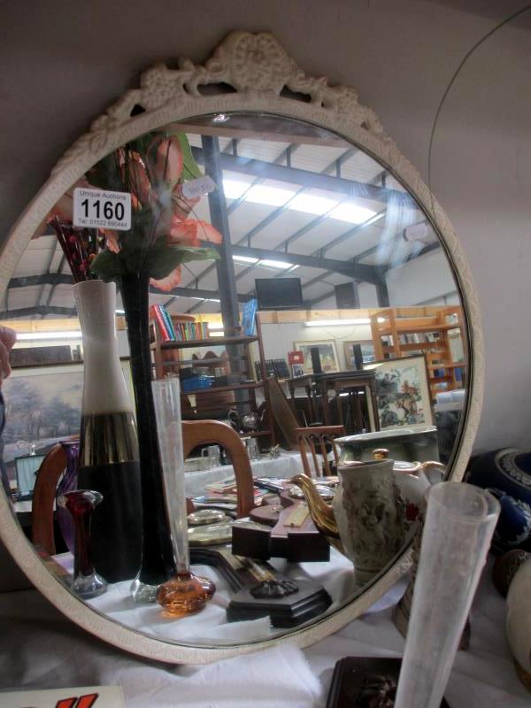 An oval mirror with white surround