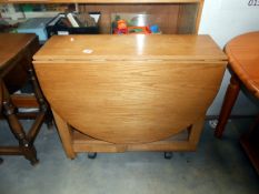 An oak drop leaf kitchen table with cupboard in centre height 75cm, open 136cm x 86cm,