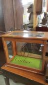A small shop display cabinet with Cartier signage.