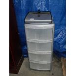 A four drawer office clear plastic cabinet and a file folder.