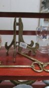 Two brass plate stands and two brass keys.