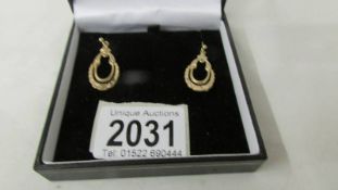 A pair of 9 carat gold ear pendants for pierced ears.