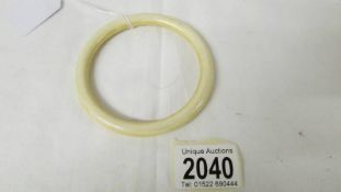 An antique ivory bangle, inside diameter 7.5 cm.