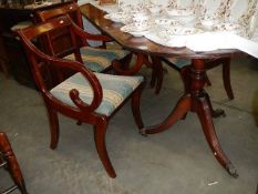 A mahogany twin pedestal extending dining table and 5 chairs.