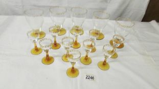 Five gold decorated lemonade glasses and 10 liquor glasses with amber glass stems.