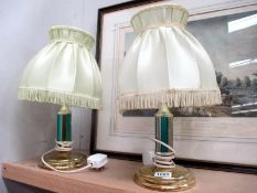 A pair of metal brass based table lamps with shades