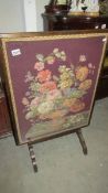 A mahogany embroidered floral fire screen with swivel action that converts from screen to small