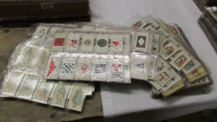 In excess of 100 sheets of cigarette cards, mostly sets, some duplicates.