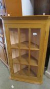 A 20th century pine corner cabinet with 9 panelled glass door.