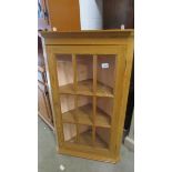 A 20th century pine corner cabinet with 9 panelled glass door.