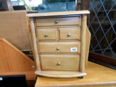A small mid coloured wooden chest of drawers with magazine racks on sides 42cm x 36cm x height 47cm