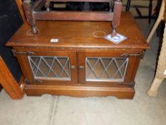 An old charm oak TV stand with leaded glass doors,