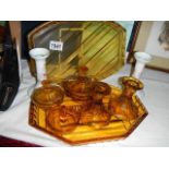 An amber glass trinket set, spare amber glass tray and pair of china candlesticks.