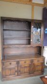A 20th century oak open rack dresser with lead glazed cupboard to side,