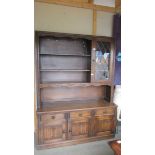 A 20th century oak open rack dresser with lead glazed cupboard to side,