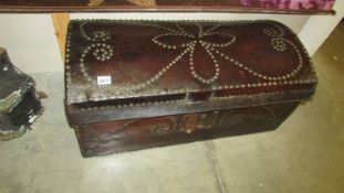 A late 18th century domed top trunk with leather covering and brass pin decoration.