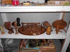 A shelf of wooden items including African head, totem pole, Russian dolls etc.