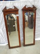 A pair of bevel edged mirrors in oak frames.