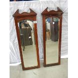 A pair of bevel edged mirrors in oak frames.