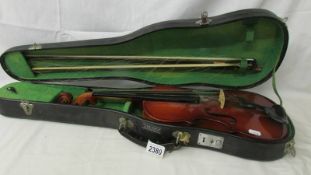 A cased violin with two bows.