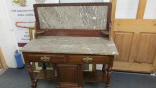An Edwardian marble top wash stand with central cupboard and 2 drawers.