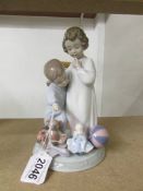 A Lladro figure group of a boy and girl with toys, 21 cm tall (a/f to boys finger).