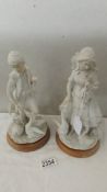 A pair of bisque figurines - boy and girl with geese.
