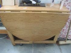 An oak drop leaf kitchen table with cupboard in centre height 75cm, open 136cm x 86cm,