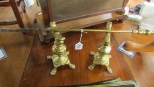 A pair of Victorian brass fire dogs and a poker.