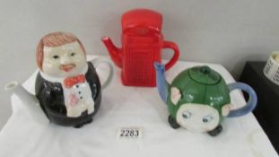 A red phone box teapot and 2 others.