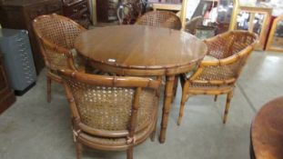 A circular bamboo dining table and 4 bamboo chairs.