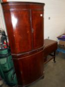 A mahogany finished corner cupboard with dentil cornice and string inlay