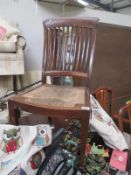 An edwardian mahogany chair with slat back and reed seat