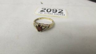 A yellow gold 1.8 gram ruby/garnet ring with 3 diamonds each side, size N.