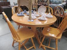 A lightwood round dining table and 4 kitchen chairs Diameter 99cm,
