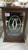 A small glazed wood display case 'Cartier'.