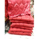 A quantity of red satin cushions.