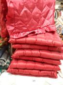 A quantity of red satin cushions.