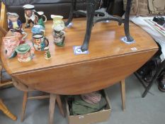 A light Ercol drop leaf table and 1 chair