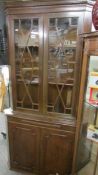 A Victorian mahogany corner cupboard with astragal glazed top doors.