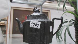 A Victorian black glazed mourning teapot, chip to lid and spout.