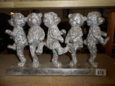 A silver- coloured teddy bear group