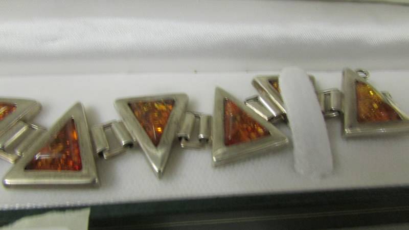 A 1960's style amber set bracelet in textured silver in a triangle design with safety chain. - Image 2 of 2