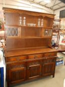 A dark oak cottage dresser with leaded glass doors