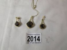 A gold on silver pendant with matching earrings.