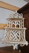 A painted fretwork corner shelf.