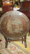 A dark wood tip top carved table with glass top.